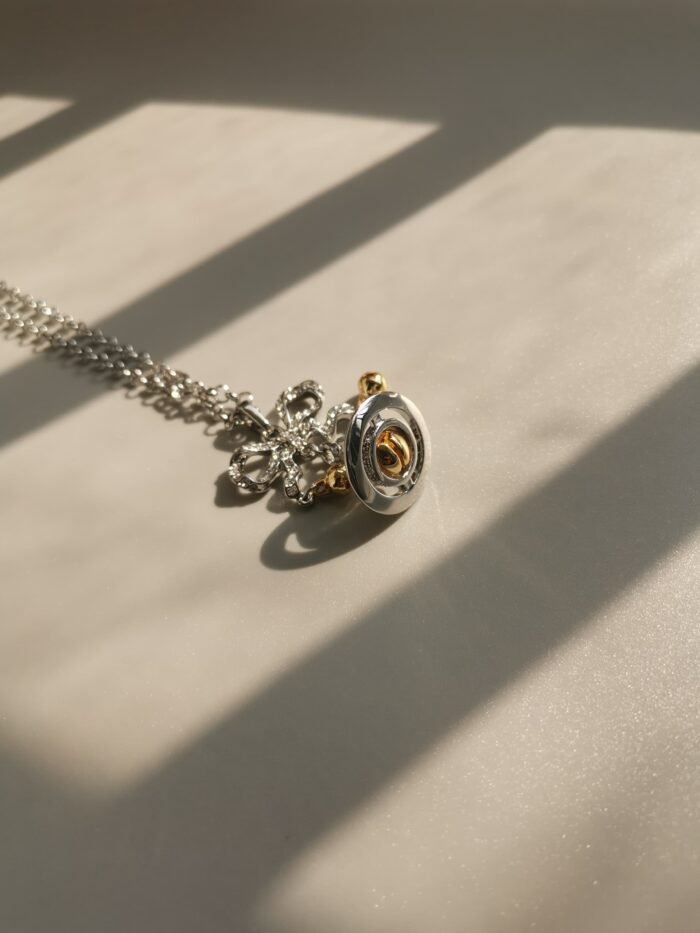 6B3E88B7-4BA1-4D4C-8B1F-907146BB6196.jpg Silver and gold bow orb necklace (with box)